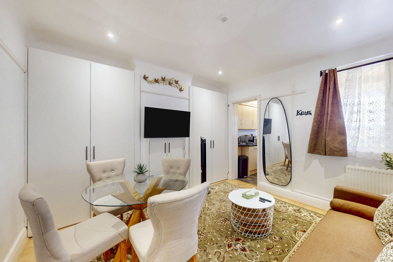 Living and dining room at the Twickenham 2-Bedroom Apartment, with glass dining table and TV